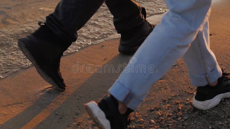 Young couple woman and man on sandy beach at sunset. hands close up