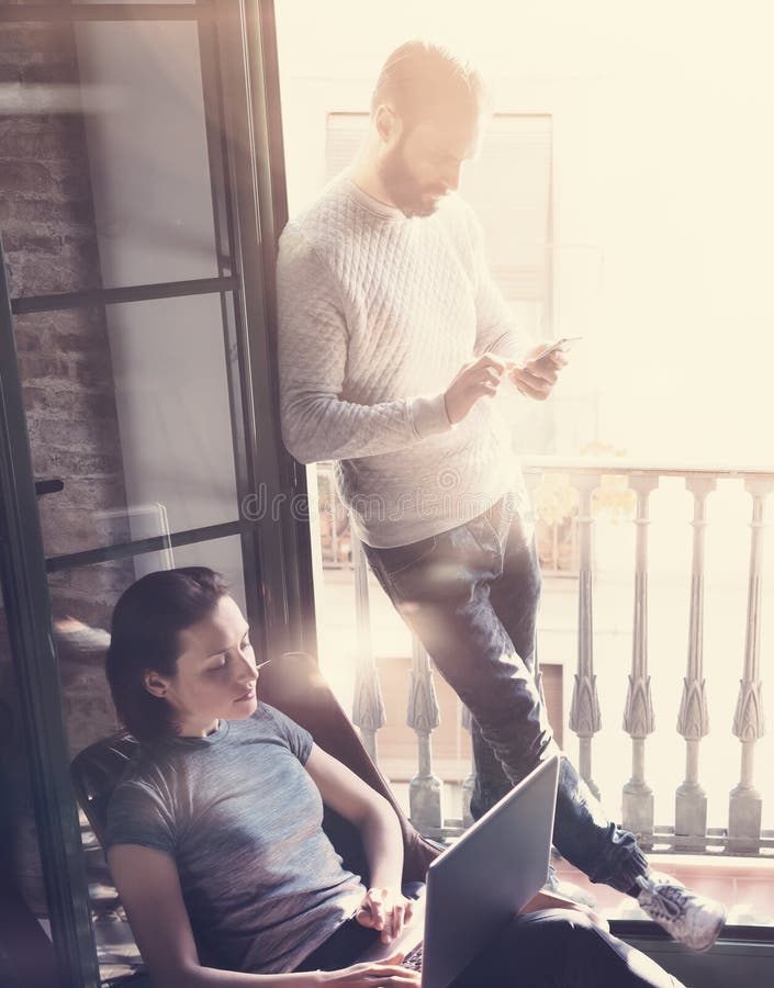 Young couple work together. Photo woman and bearded man working with new startup project in modern loft. Using royalty free stock photo Young couple work together. Photo woman and bearded man working with new startup project in modern loft. Using royalty free stock photo