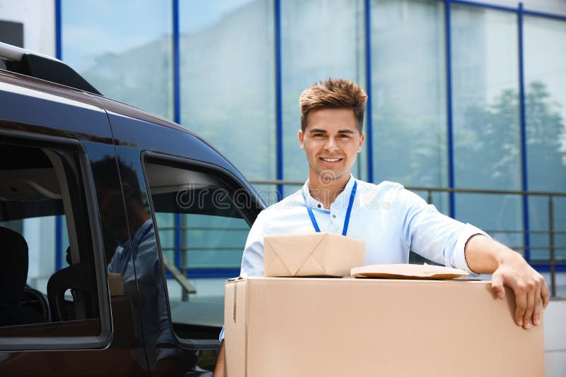 Young courier with parcels delivery car outdoors stock images.