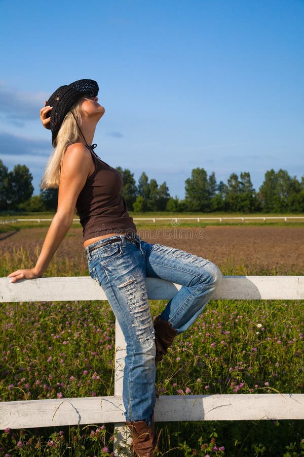 Young cowgirl sitting on a fence