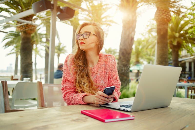 Young creative woman work on laptop while having breakfast on terrace stock images Young creative woman work on laptop while having breakfast on terrace stock images