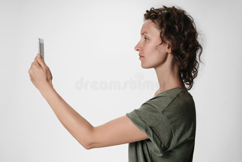 Young curly hair woman using smartphone face recognition isolated on white royalty free stock images Young curly hair woman using smartphone face recognition isolated on white royalty free stock images
