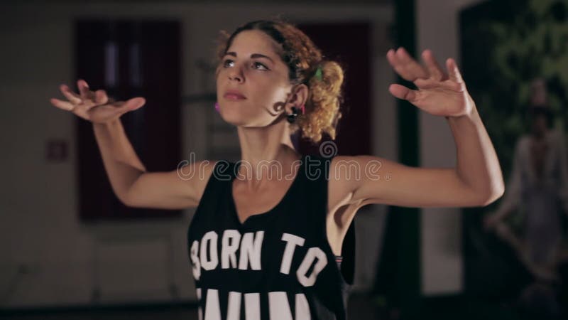 Young cute girl dancing in dark studio