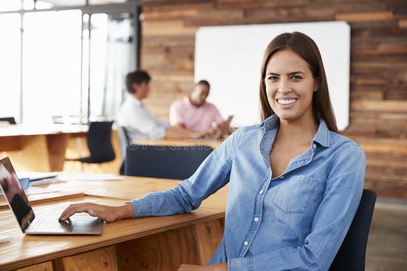 Young dark haired woman sitting in office looking �to camera stock photos Young dark haired woman sitting in office looking �to camera stock photos