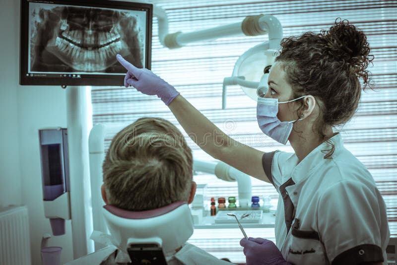 Young dentist examining medical X-ray with patient. royalty free stock photo Young dentist examining medical X-ray with patient. royalty free stock photo