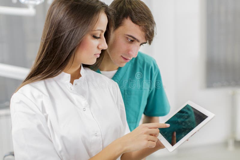 Young dentists with tablet stock images