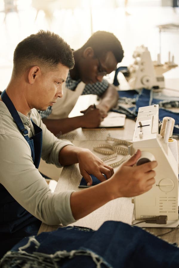 Young Designer Using a Sewing Machine. Tailor Getting His Sewing
