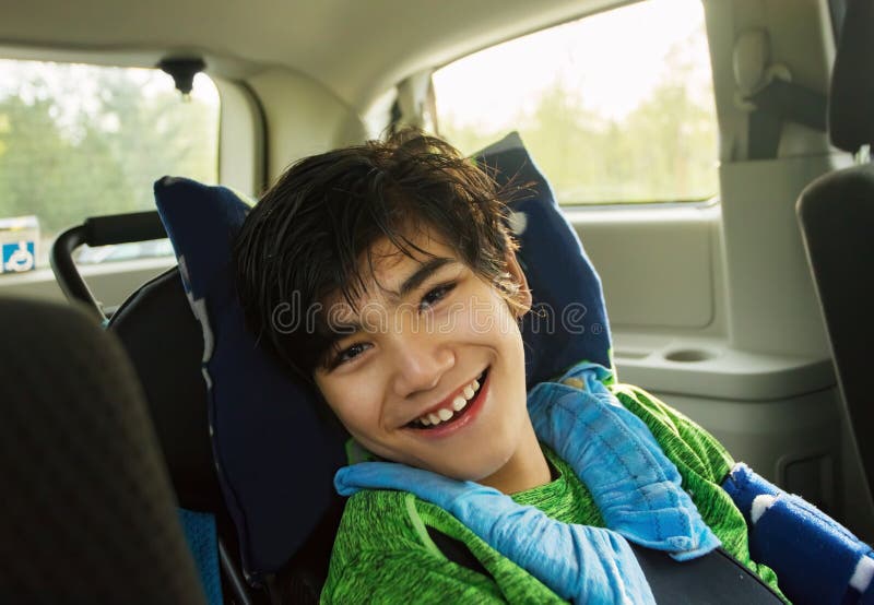 Young disabled boy in wheelchair traveling in handicap vehicle