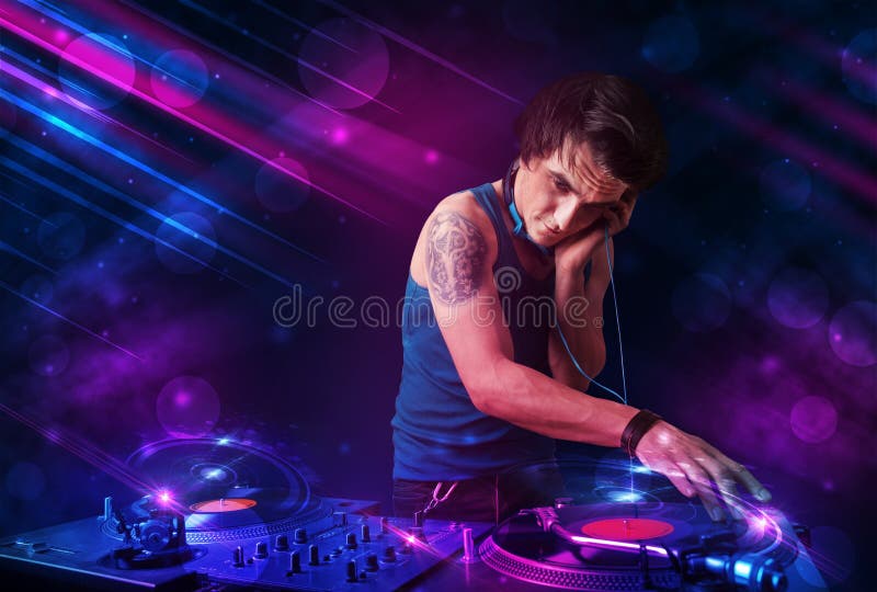 Young DJ Playing on Turntables with Color Light Effects Stock Image