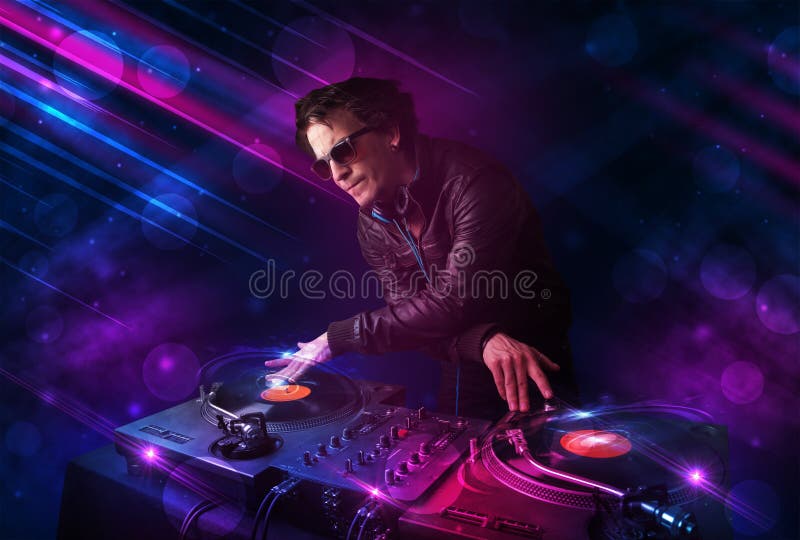 Young DJ Playing on Turntables with Color Light Effects Stock Image