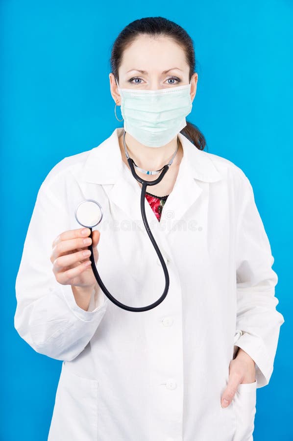 Young doctor in mask holds stethoscope