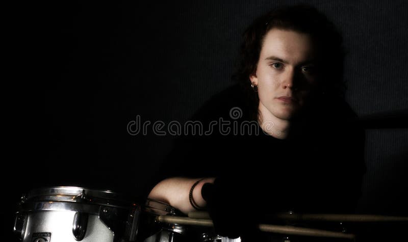 Young man posing at a drum kit. Young man posing at a drum kit.