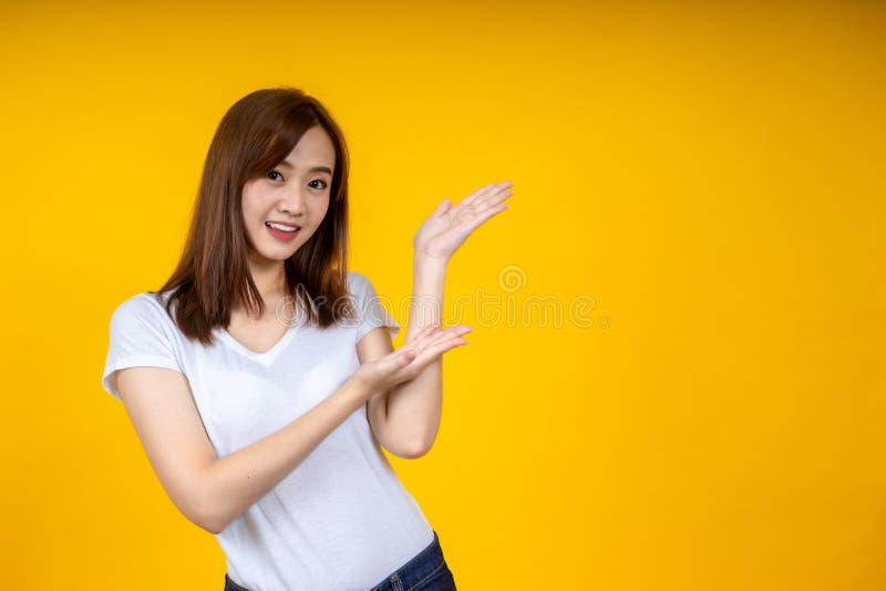 Young elegant Asian woman smiling and pointing to empty copy space royalty free stock images Young elegant Asian woman smiling and pointing to empty copy space royalty free stock images