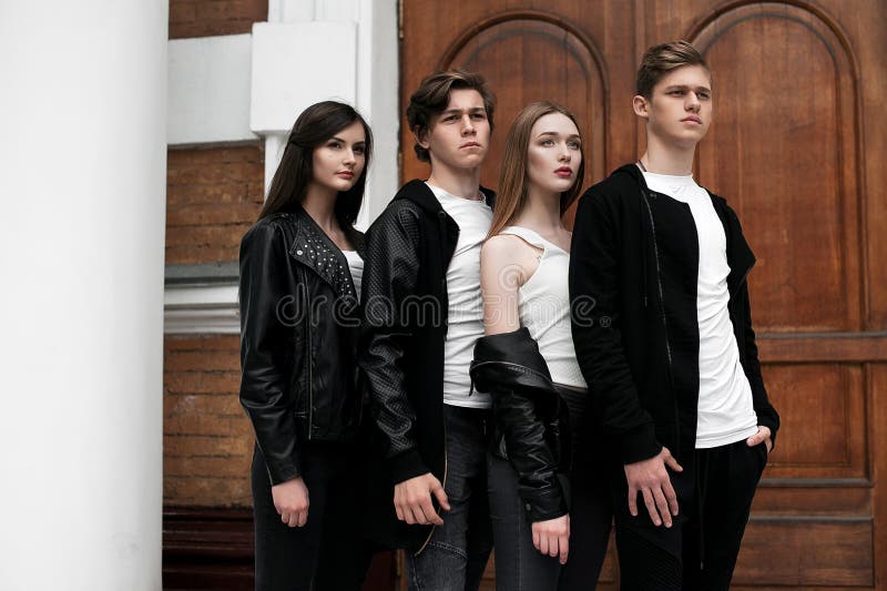 Young elegant trendy friends outdoors, wearing black and white clothing royalty free stock photo Young elegant trendy friends outdoors, wearing black and white clothing royalty free stock photo