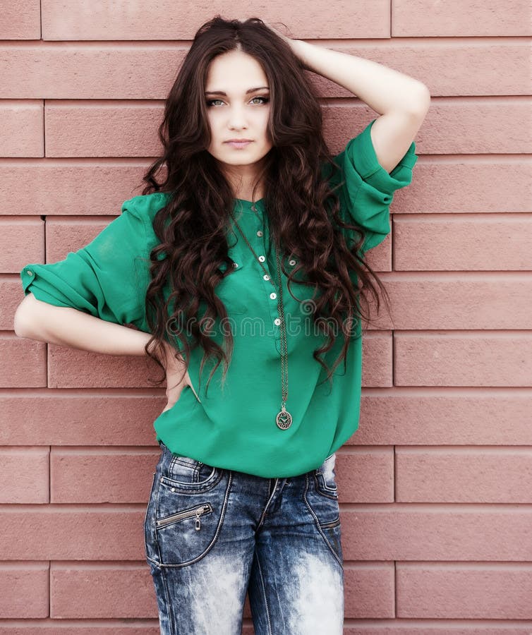 Young elegant woman on a brick wall backround