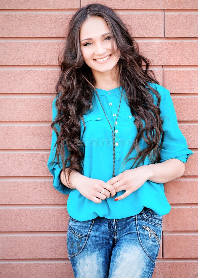 Young elegant woman on a brick wall backround