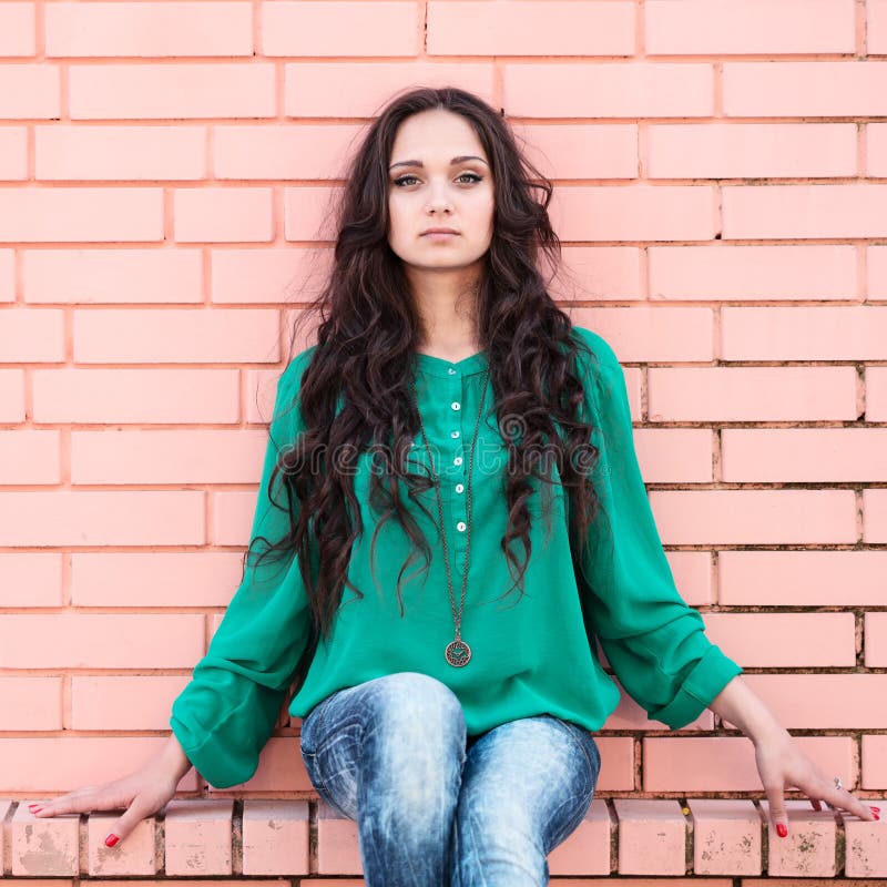 Young elegant woman on a brick wall backround