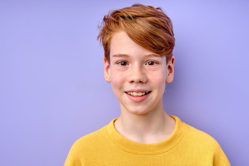 Young emotional handsome boy standing on purple studio background.