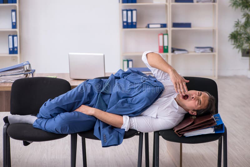 Young Male Employee Sleeping in the Office on Chairs Stock Image