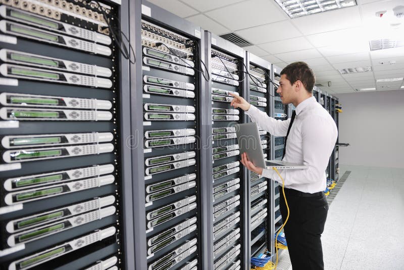 Mladý pohledný obchodní muž engeneer v datacenter server pokoj.