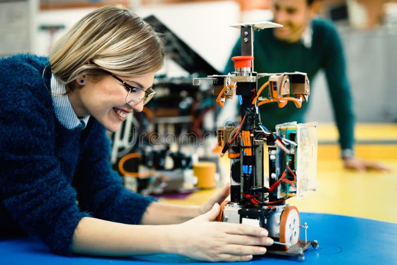 Young engineer testing her robot in workshop royalty free stock images