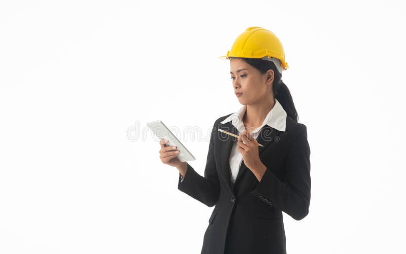 Young engineer woman wear black suit and yellow safety helmet holding note or tablet on isolated white background