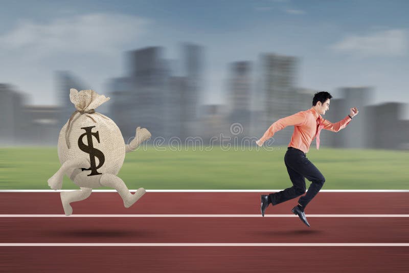 Young entrepreneur chased by bag of dollar. Young entrepreneur is being chased by a bag of dollar on the track royalty free stock photo Young entrepreneur chased by bag of dollar. Young entrepreneur is being chased by a bag of dollar on the track royalty free stock photo