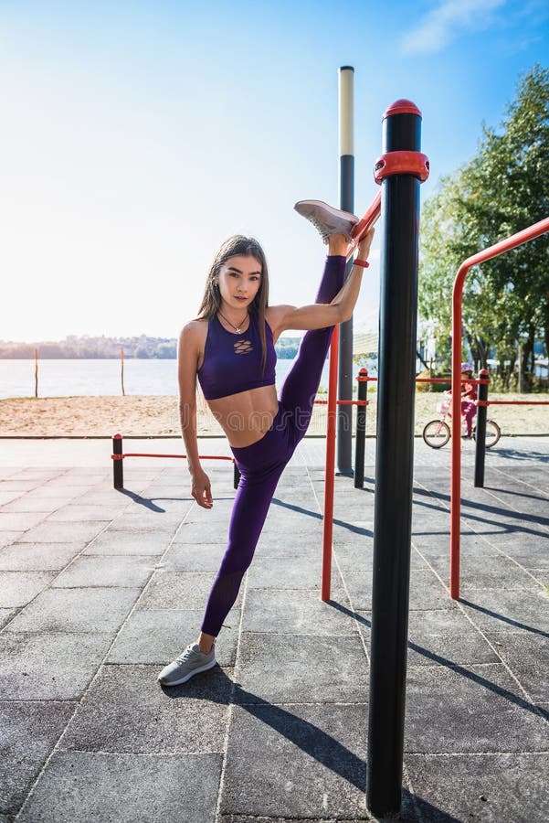 Young European Female Athlete Hanging on Wall Bars Doing Twine Outside ...