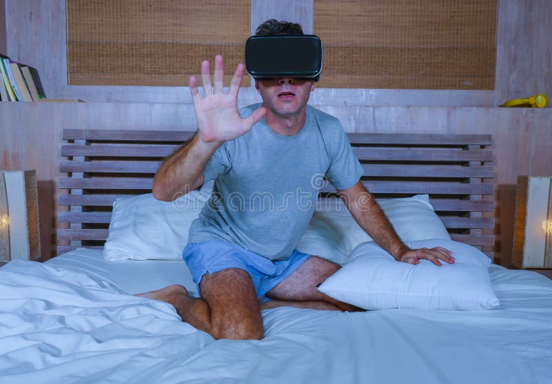 Young excited and amazed man wearing VR virtual reality goggles device playing internet 3D simulator game enjoying exciting and royalty free stock images Young excited and amazed man wearing VR virtual reality goggles device playing internet 3D simulator game enjoying exciting and royalty free stock images