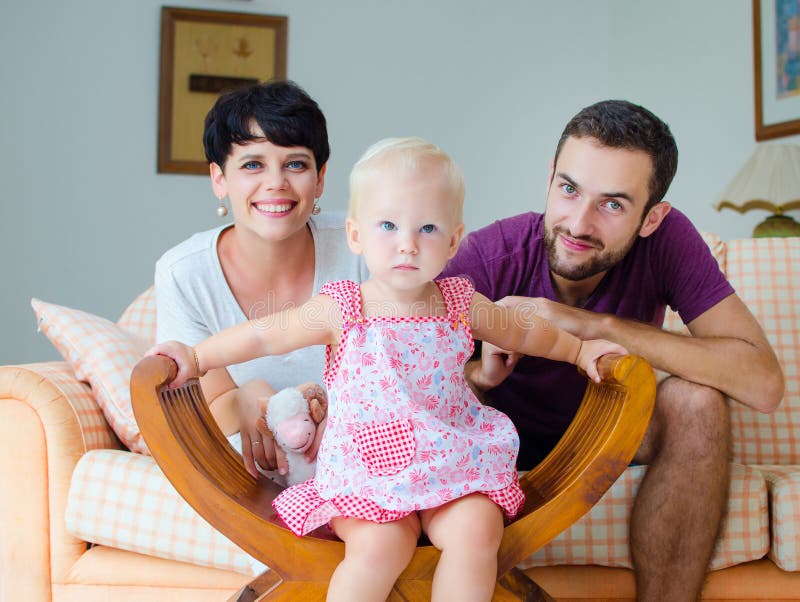 Young Family At Home On The Weekend. Family Drinking Tea. Stock Photo