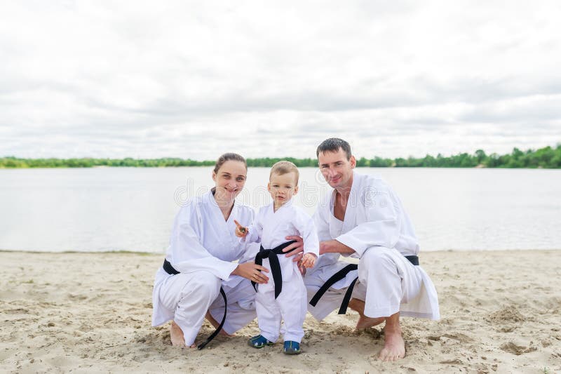 Father, mother and little son - sport family. Young family in kimono outdoors. royalty free stock images Father, mother and little son - sport family. Young family in kimono outdoors. royalty free stock images