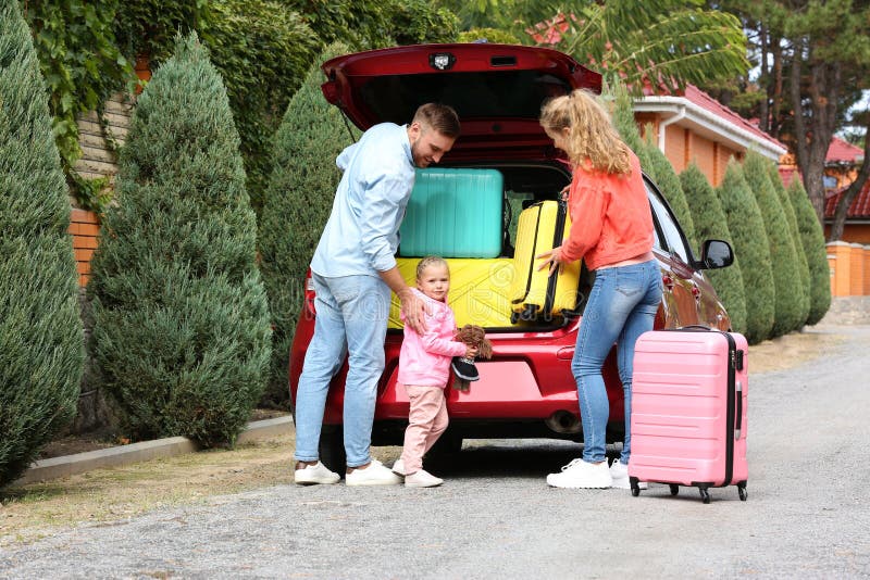 Young family loading suitcases in car trunk royalty free stock images Young family loading suitcases in car trunk royalty free stock images