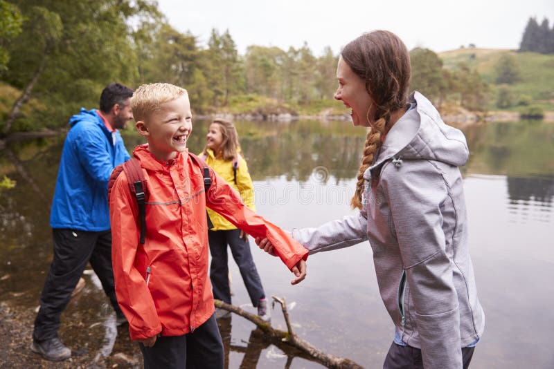 Young family playing with their children on the shore of a lake, close up, Lake District, UK royalty free stock photo Young family playing with their children on the shore of a lake, close up, Lake District, UK royalty free stock photo