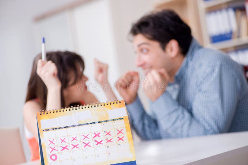 Young family in pregnancy planning concept with ovulation calend royalty free stock photography Young family in pregnancy planning concept with ovulation calend royalty free stock photography