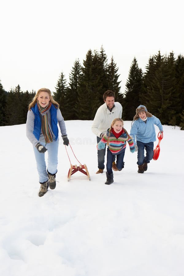 Young Family Running Through Snow With Sled stock images Young Family Running Through Snow With Sled stock images