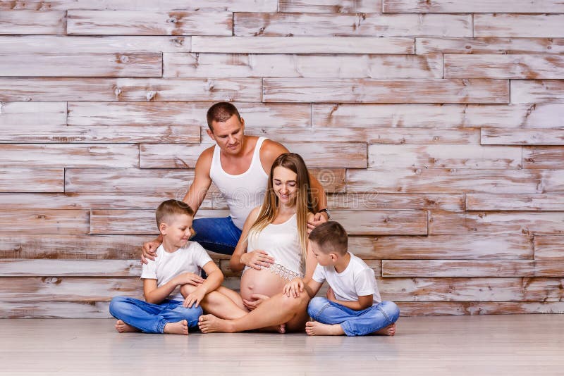 A young family waiting for their third child . pregnant woman looks at her belly stock photo A young family waiting for their third child . pregnant woman looks at her belly stock photo