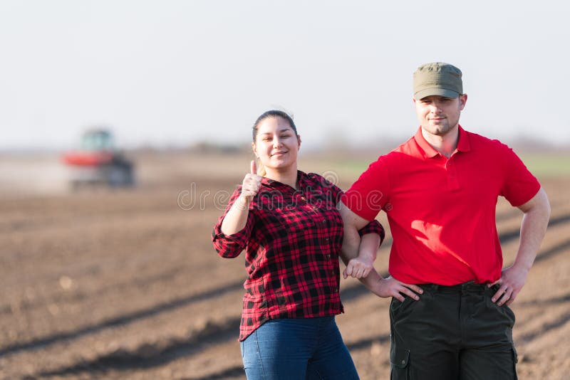 Young farmers examing planted wheat fields