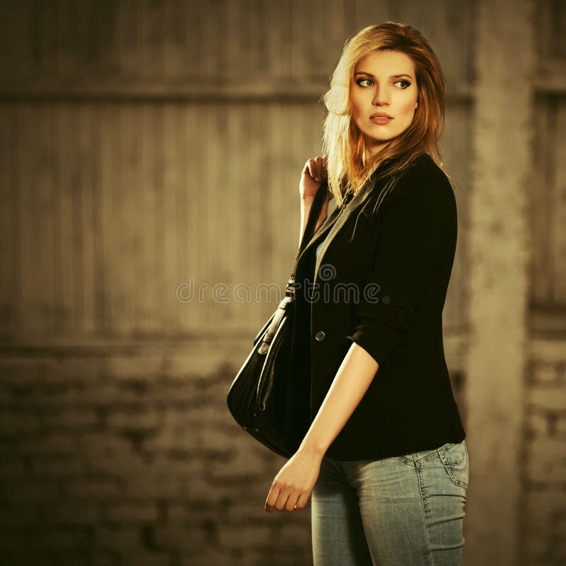 Young fashion blond business woman with handbag walking on city street stock photos Young fashion blond business woman with handbag walking on city street stock photos
