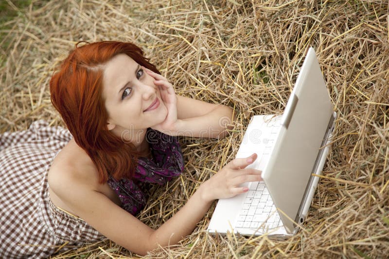 Young fashion girl with notebook lying at field