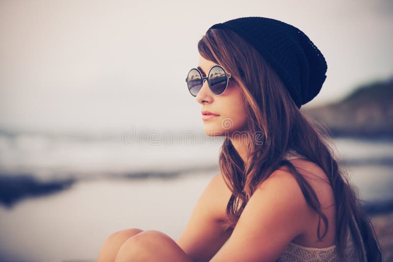 Fashion portrait der Jungen hipster-Frau mit Hut und Sonnenbrille am Strand bei Sonnenuntergang, retro-Stil, Farbe Tönen.