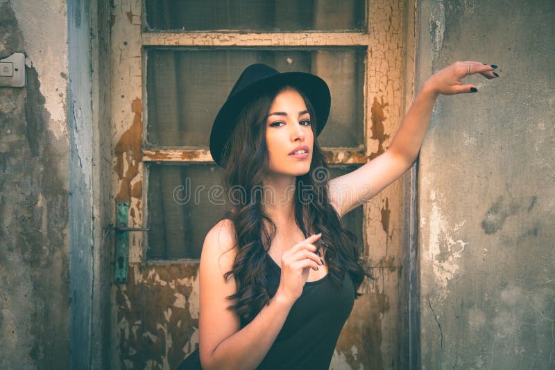Young fashion woman with hat stand in front old abandoned house royalty free stock image Young fashion woman with hat stand in front old abandoned house royalty free stock image