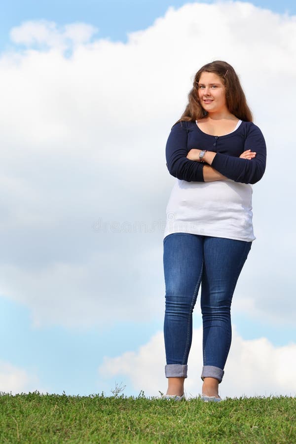 Young fat girl stands at grass