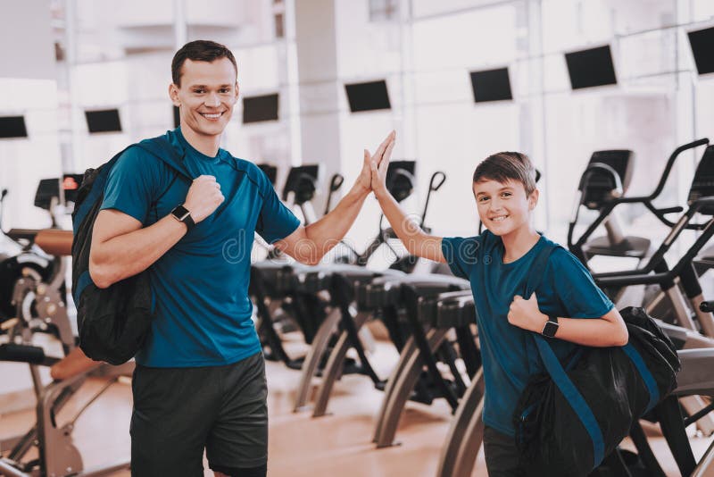 Young Father and Son near Treadmills in Modern Gym stock photography Young Father and Son near Treadmills in Modern Gym stock photography