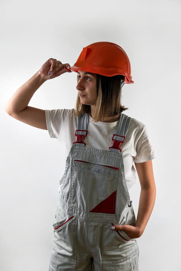 Young female architect builder posing in uniform and helmet smiling. stock photography
