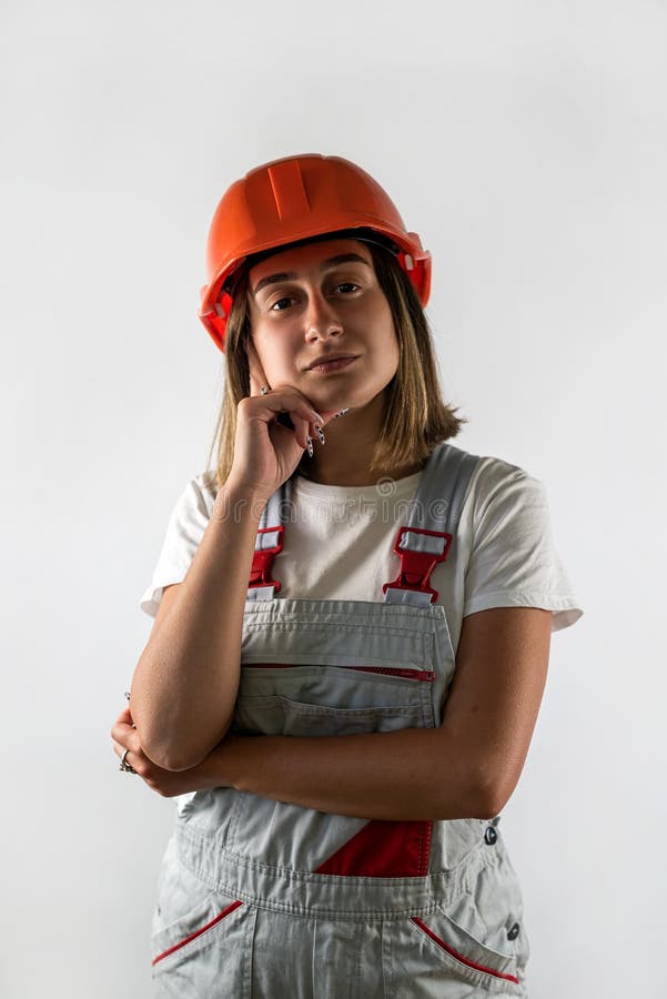 Young female architect builder posing in uniform and helmet smiling. royalty free stock image