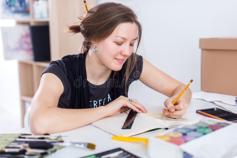 Female Painter Drawing in Art Studio Using Easel. Portrait of a Young ...