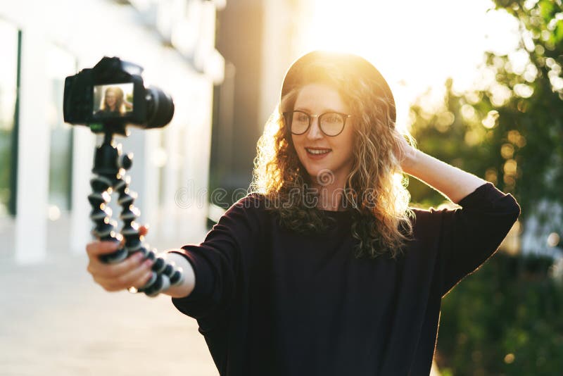 Young Female Blogger in Trendy Glasses and Hat Walks on City Street ...