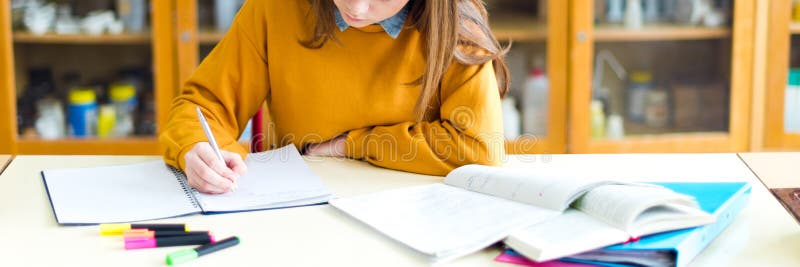 Mladá žena studentka v hodině chemie, psaní poznámek. Soustředěný student ve třídě.