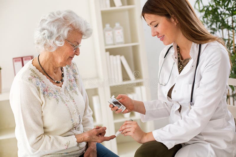 Young female doctor making diabetes blood test on senior woman. Closeup stock images