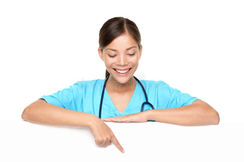 Beautiful young female doctor pointing at copyspace over white background